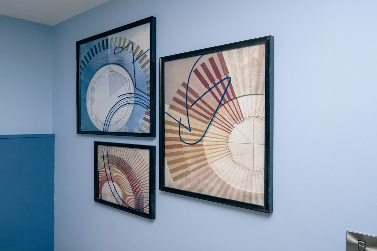Three framed abstract artworks on a wall.