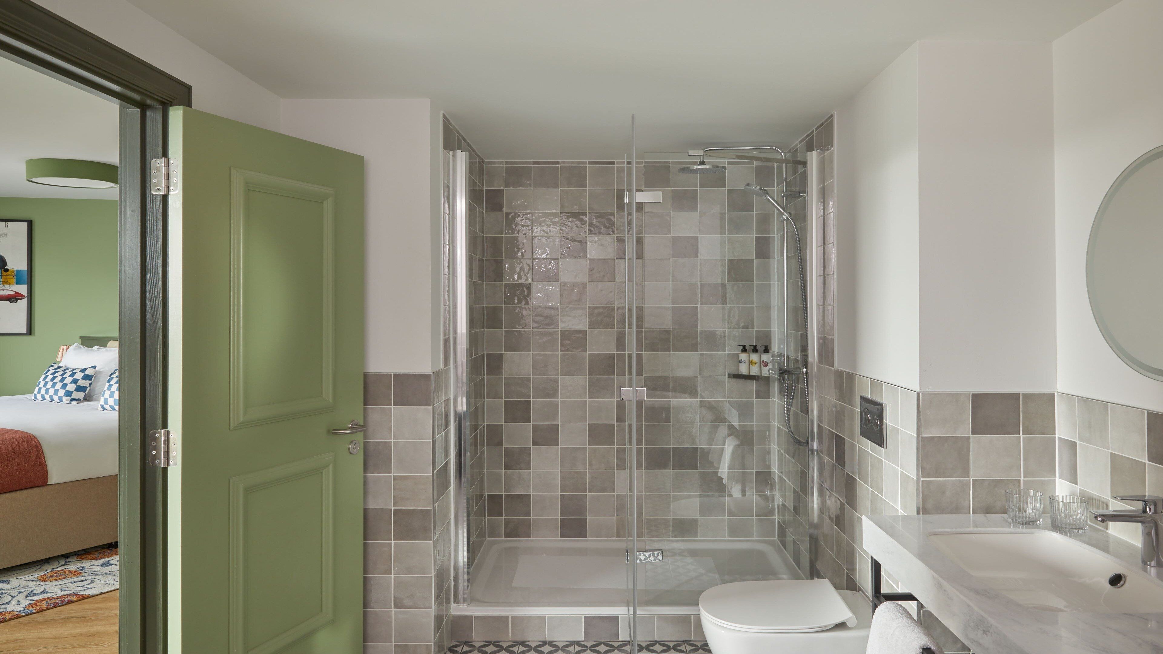 A modern bathroom with a glass-enclosed shower, a toilet, and a sink.