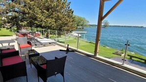 Eine Terrasse im Freien mit Korbmöbeln und Seeblick.