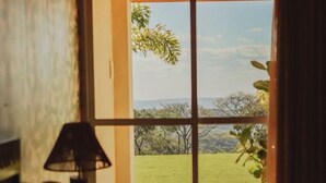 Una habitación con vistas a un espacio verde con árboles, visible a través de un ventanal.