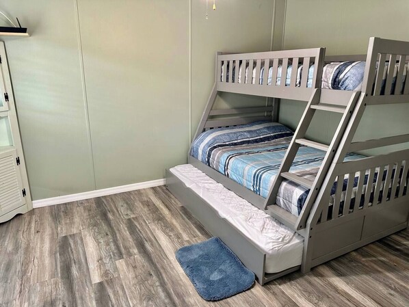 A bunk bed with a wooden frame and a blue mat at the foot of the bed.