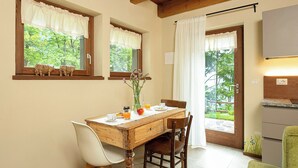 Un comedor con una mesa de madera, sillas y un ventanal con vistas a follaje.
