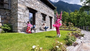 A stone building with a grassy lawn and a garden with flowers. - Baita Athili - Crodini Village (Piemonte)