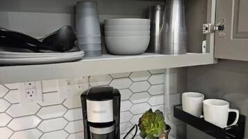 A kitchen with a coffee maker, a tray with a book, a candle, and a small plant.