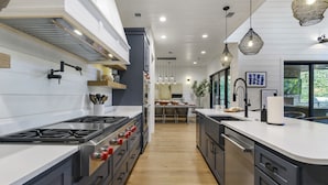 A modern kitchen with a central island, stainless steel appliances, and pendant lighting.