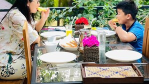 A dining table set outdoors with plates, glasses, and a pitcher. - Sigiri Holiday Bungalow (Sigiriya)