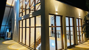 A modern building with large windows and a staircase leading to an upper level. - Sigiri Holiday Bungalow (Sigiriya)