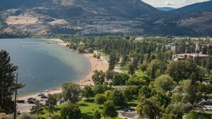 Une ville côtière dotée d’une plage, avec des montagnes en arrière-plan, et où se côtoient des bâtiments résidentiels et commerciaux.