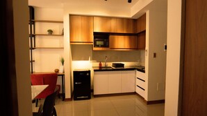 A compact kitchen with white cabinets, a microwave, and a small refrigerator. - Beautiful Loft in a brand new Condo, 10 minutes from business center.  (Santa Cruz de la Sierra)