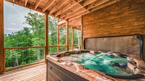 A hot tub with a view of a forest.