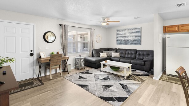 En stue med sofa, sofabord og et spiseområde med bord og stole.