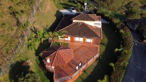 An aerial view of a house with a large patio area, multiple rooms, and a fenced yard. - Finca-hotel Montecarlo by Hope (Antioquia)