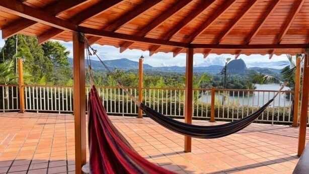 A hammock under a wooden pergola on a tiled patio with a view of a lake and mountains. - Finca-hotel Montecarlo by Hope (Antioquia)