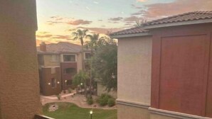 A balcony with a view of a residential area, including houses and a lawn.