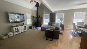 A living room with a television, sofa, and a fireplace. - Peaceful Hideaway! New Listing (Roscommon)