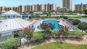 Un hotel con piscina, terraza techada y vistas de edificios altos circundantes.