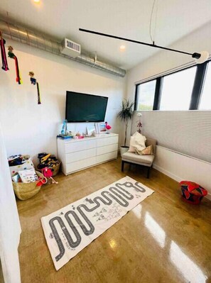 Relax in a spacious room with a large flat-screen TV, comfortable seating area, and decorative rug.