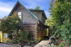 A wooden cabin with a sloped roof, a number '267' on the side, and a covered porch area.