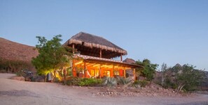 Guests can enjoy a serene atmosphere at this traditional-style guesthouse with a thatched roof, set amidst a natural landscape.