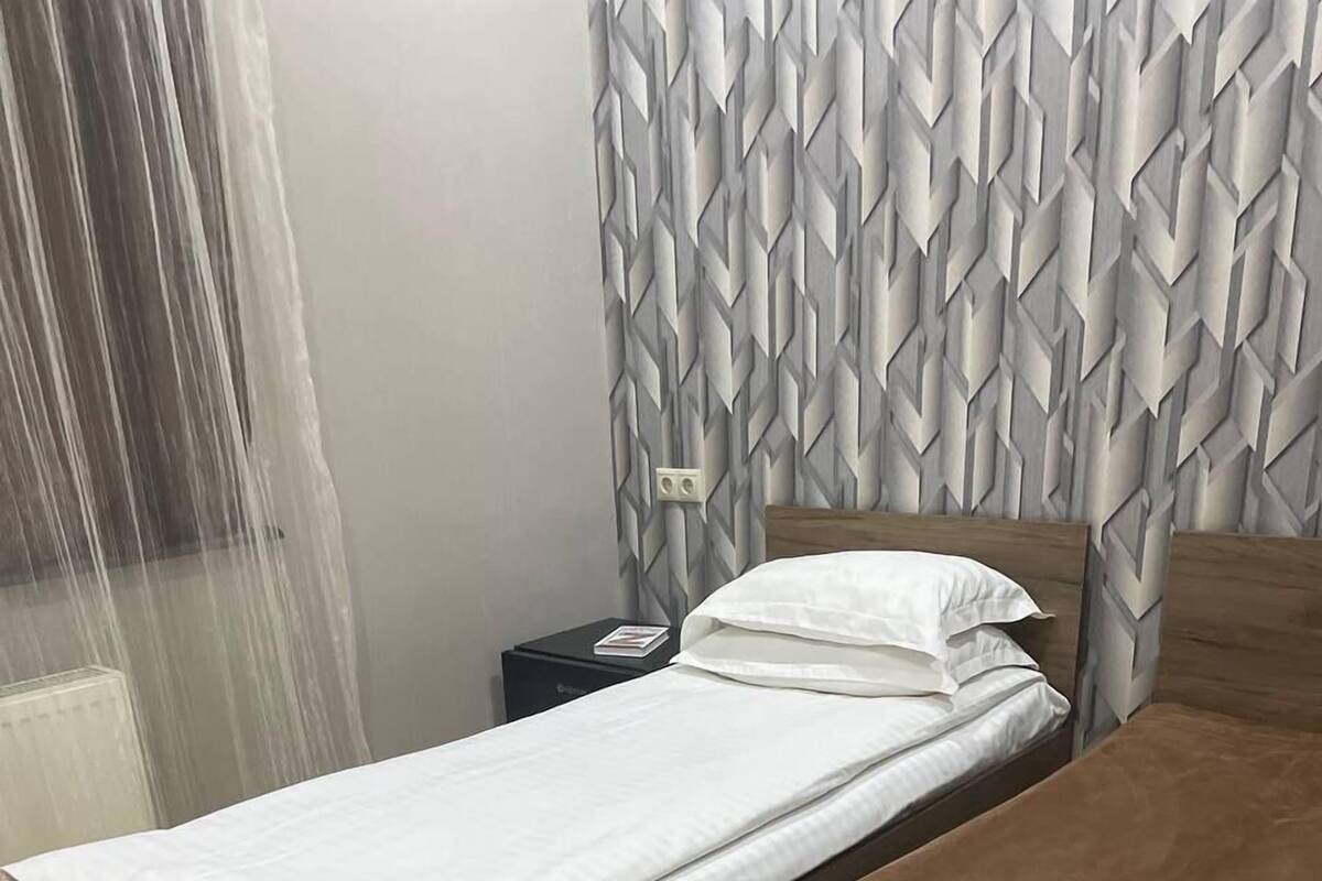 Una cama doble con estructura de madera y colchón marrón.