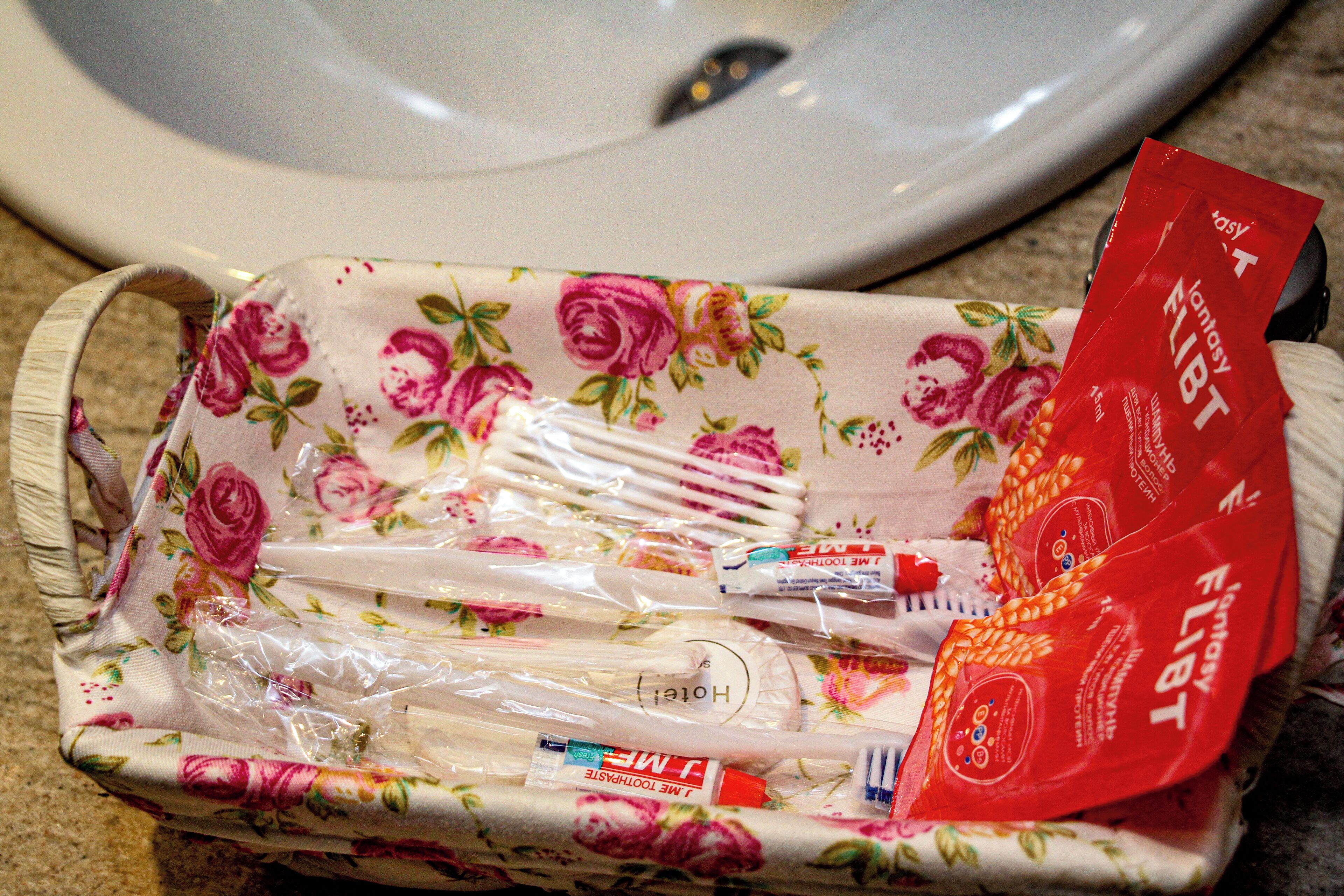 A floral-patterned toiletry bag containing toothbrushes and a red Fantasy FLIGHT toothbrush pack.