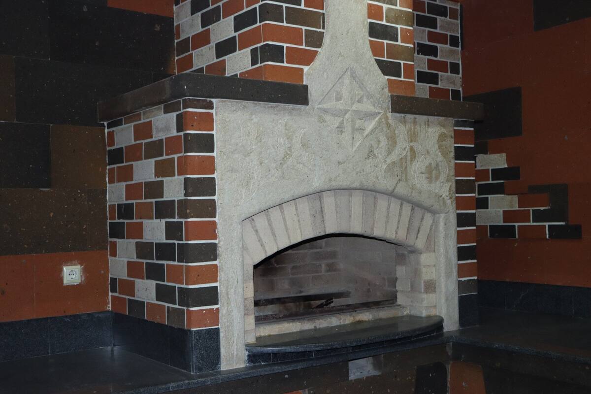 Una chimenea de ladrillo con diseño de estrella, ubicada en una esquina con una encimera negra.