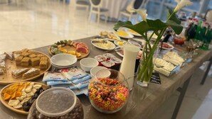 Une table de buffet garnie de divers plats et un grand verre de lait.
