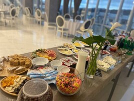 Una mesa de buffet con diversos alimentos y un vaso grande de leche.