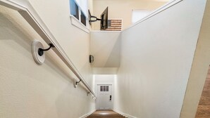 Eine Treppe mit Holzbodenstufen und weißen Wänden, die zu einer Tür führt.