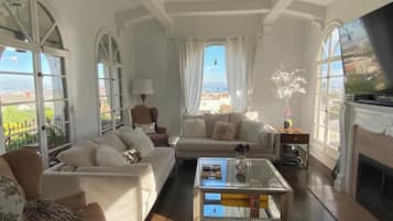 Smart TV, lareira, livros, aparelho de som