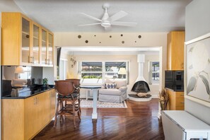 A modern kitchen with wooden cabinets, a dining area with a table and chairs, a fireplace, and a ceiling fan. - 1.5/h theme parks, close to mall,  golf course, 15min to beach, 5min Downtown!  (Melbourne)