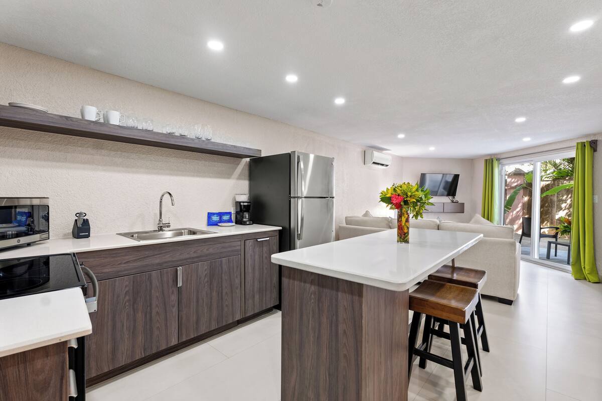 A modern kitchen with a central island, built-in appliances, and a dining area with a sofa and bar stools.