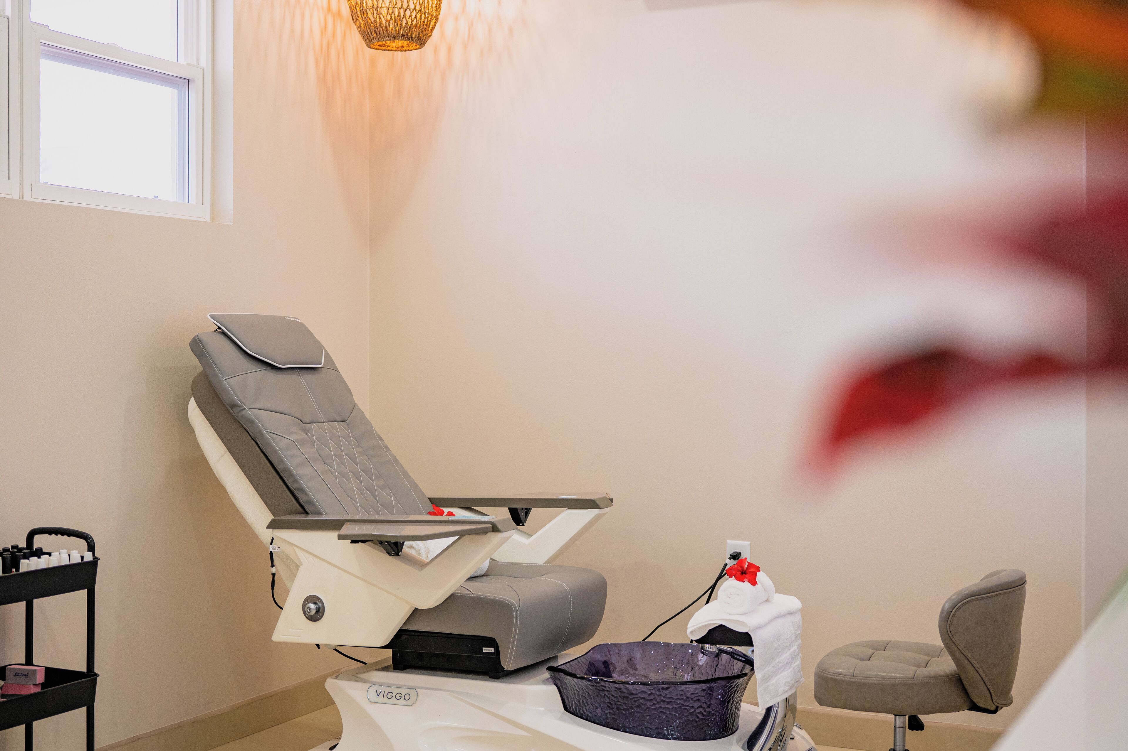 A dental chair with a headrest, a small table with a tissue box, and a basket on the floor.