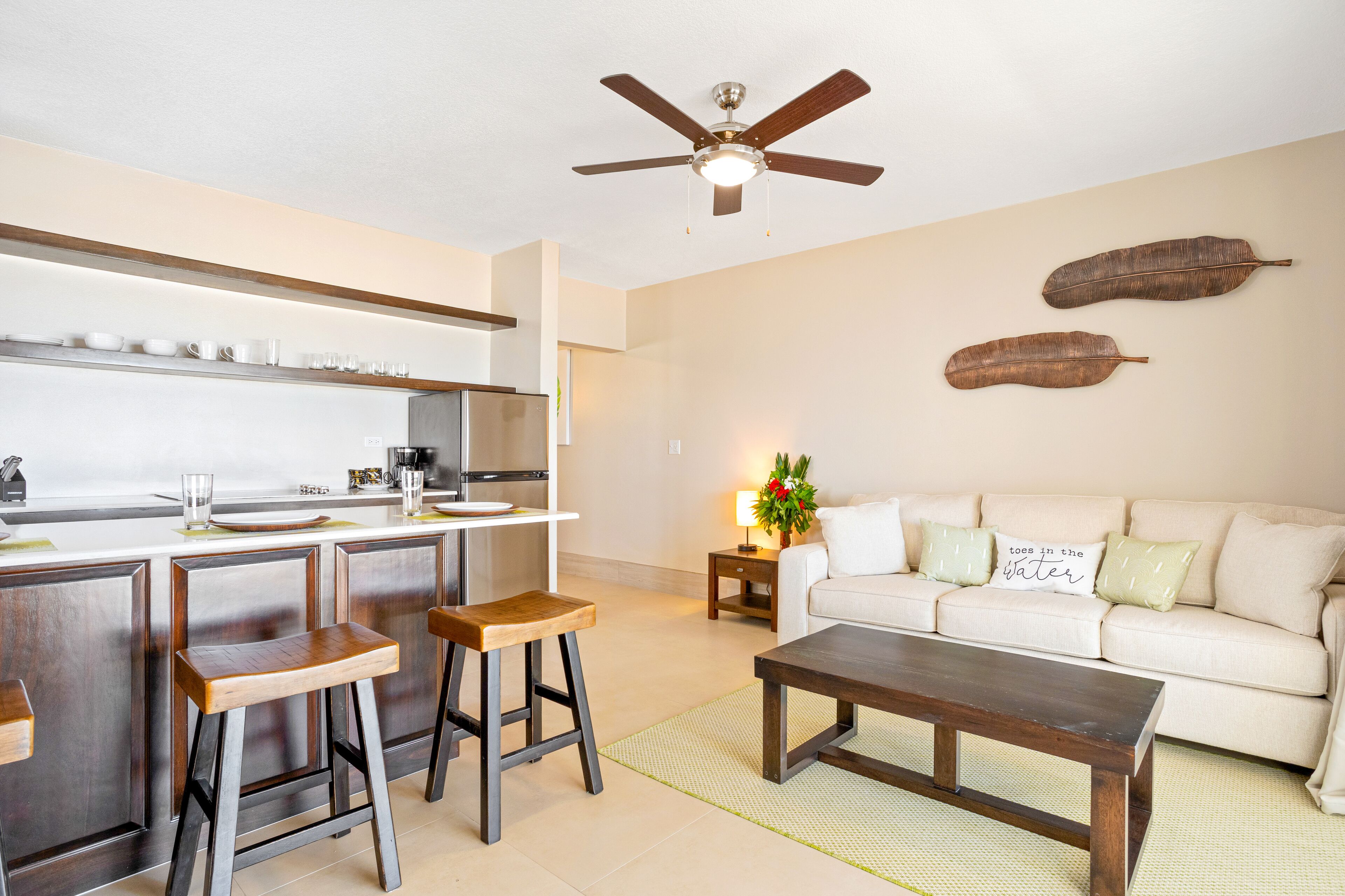 Una cocina moderna con taburetes de madera, una mesa de comedor y un ventilador de techo.