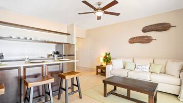 Una cocina moderna con taburetes de madera, una mesa de comedor y un ventilador de techo.