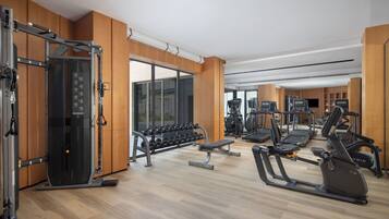 A gym with various exercise equipment, including treadmills, elliptical machines, and free weights.