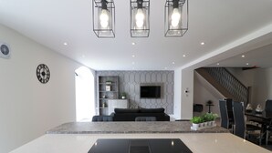A modern kitchen with a central island, built-in appliances, and pendant lighting. - Northumberland Luxury Stays - The Gavel (Northumberland)