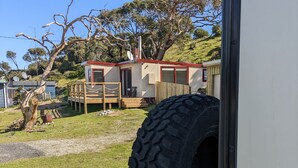 A vehicle parked in a grassy area with a house in the background.