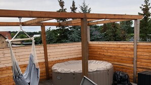 A wooden deck with a hammock, an inflatable hot tub, and a foldable table. - Apartment 'Am Stettiner Haff' with Private Pool, Private Terrace and Wi-Fi (Mönkebude)
