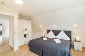 A bedroom with a bed, bedside tables, a wardrobe, and a mirror. - 'Unique Apartments' in Central Wiesloch with Private Terrace and Wi-Fi (Wiesloch)