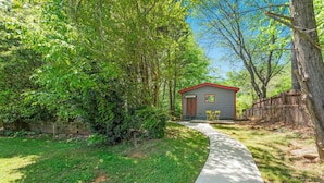 Une petite maison avec un toit rouge et un chemin qui y mène.