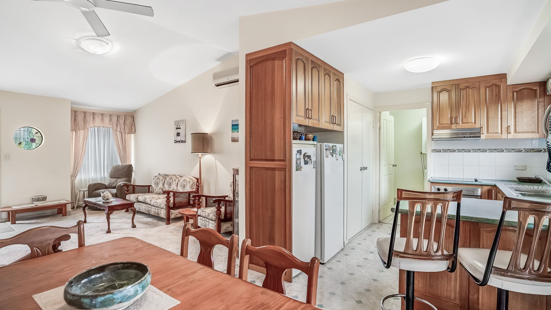 A compact living space with a dining area, kitchen, and a living room.