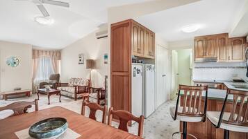 A compact living space with a dining area, kitchen, and a living room.