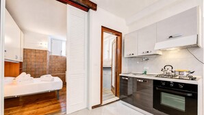 A compact kitchen with a stove, oven, and white cabinets.