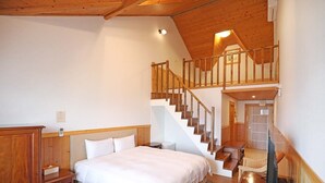A bedroom with a wooden staircase, a bed, a nightstand, and a chair. - Baili Manor Cing Jing (Ren'ai)