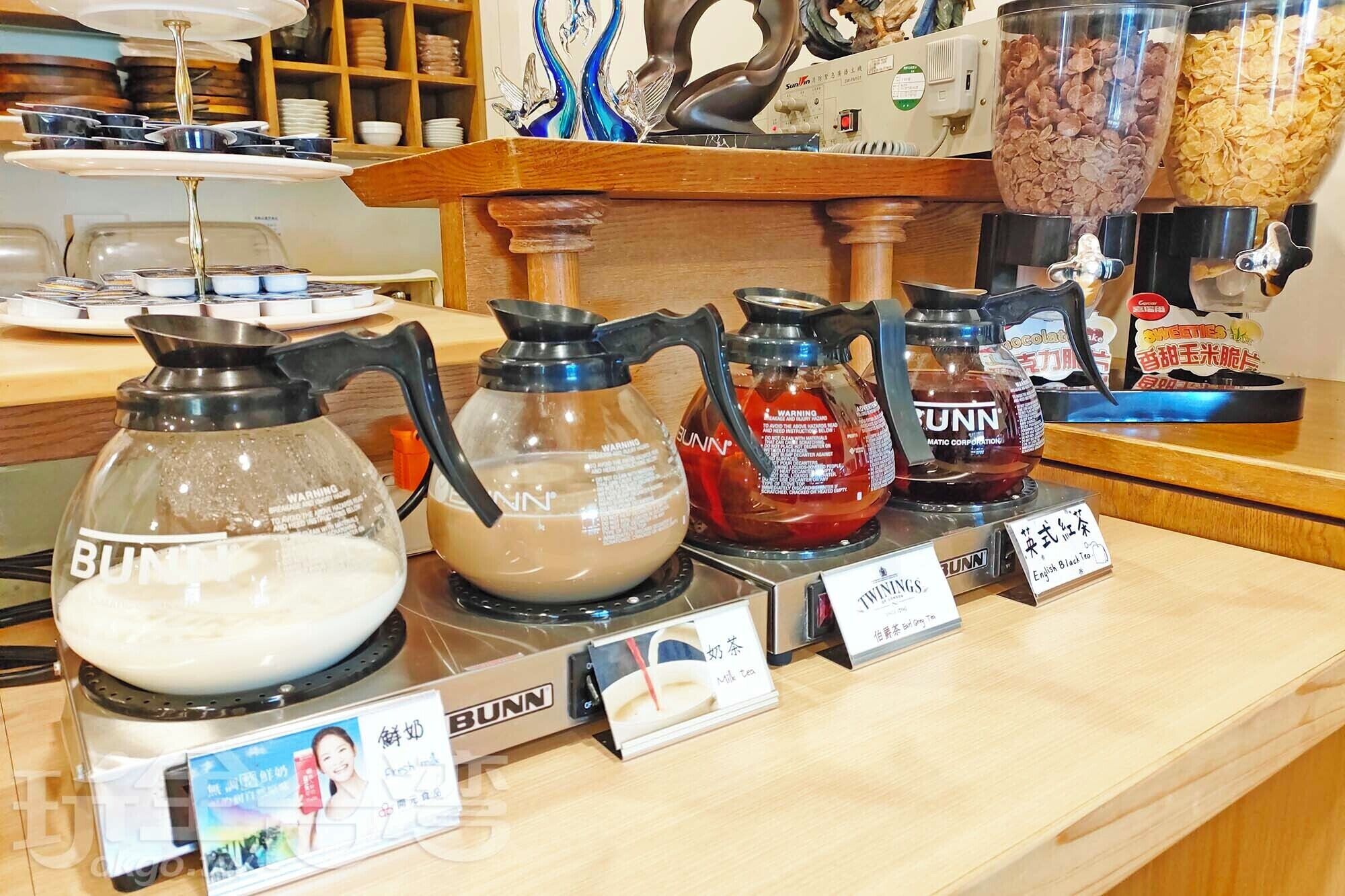 A coffee station with various brewing equipment and labeled tea options.