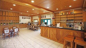 A wooden interior with a bar area, seating, and shelves with bottles. - Baili Manor Cing Jing (Ren'ai)