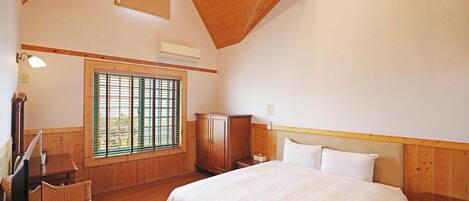Un dormitorio con una cama grande, paredes de madera, una ventana con persianas, un escritorio y una silla.