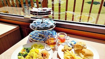 Una mesa con comida y bebidas en un balcón.