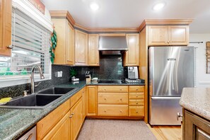Enjoy cooking in this well-equipped kitchen with a refrigerator, dishwasher, and sink.